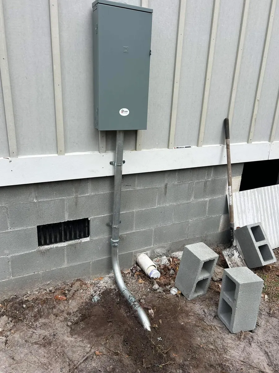Exterior 200-amp service panel and conduit riser installed by Whitehouse Electric.